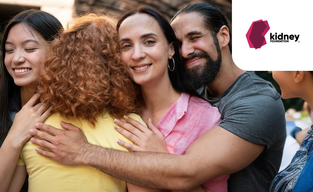 A group of people from different ethnicities and genders hugging together. The logo of The Kidney Foundation is on the corner.