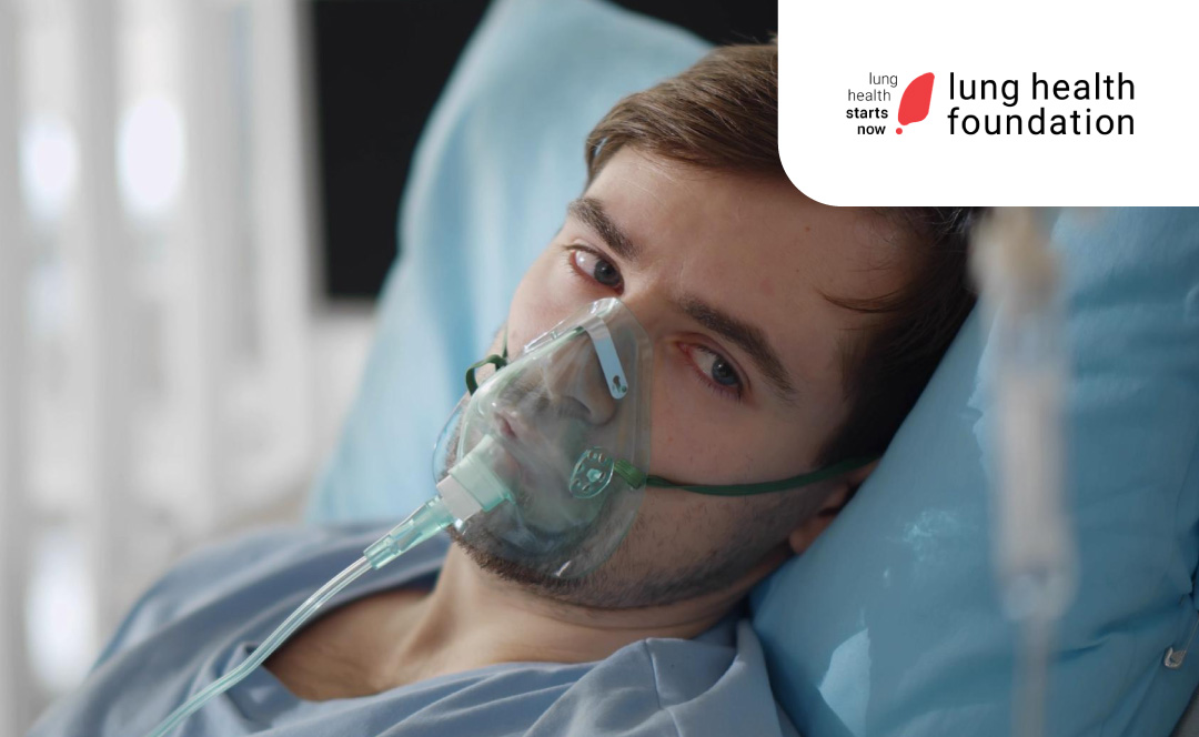 Pacient with oxygen mask in a hospital's room. The Lung Health Foundation logo is on the corner.
